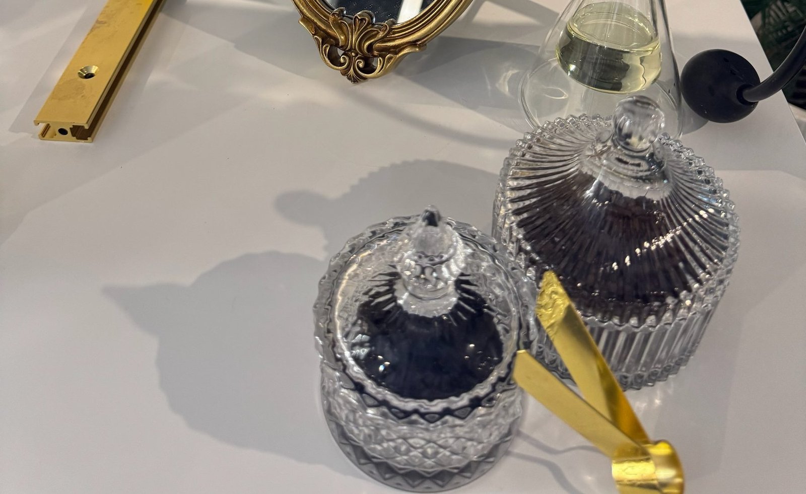 Cut-crystal lidded jars, gold tongs and an antique gold mirror frame styled on the Essence & Co. perfume bar